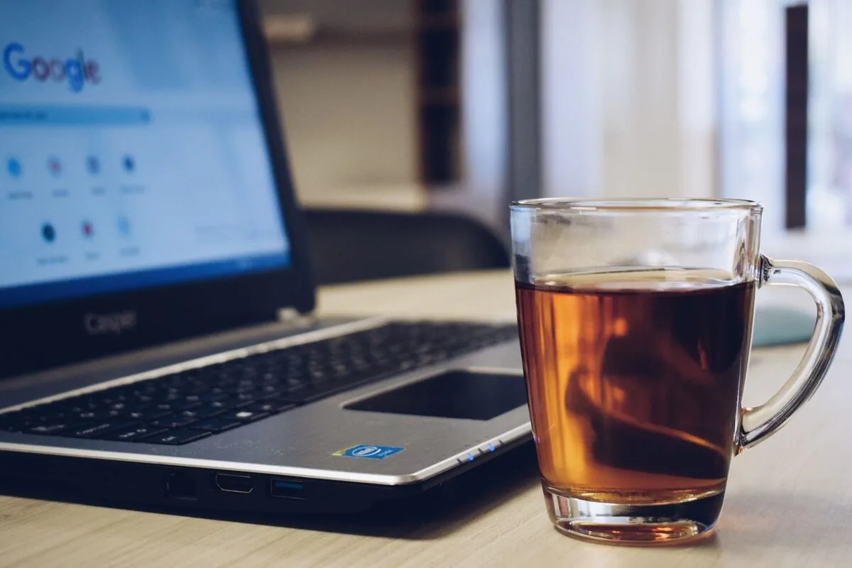 Otwarty laptop obok szklanki z płynem na biurku — Komunikat „No bootable device" na laptopie Lenovo
