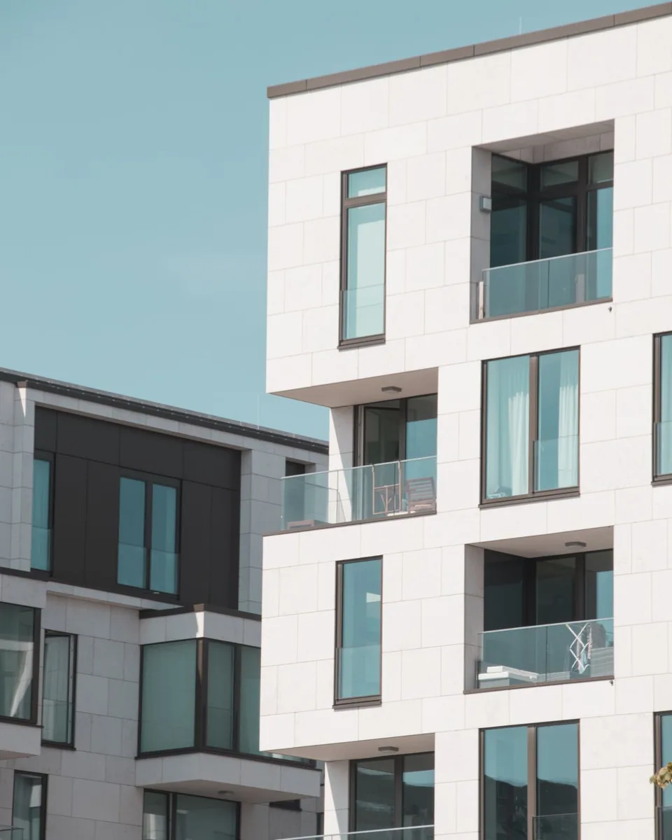 Nowoczesny biały apartamentowiec z przeszklonymi balkonami — Naprawa laptopa Lenovo Białołęka — jak zamówić odbiór