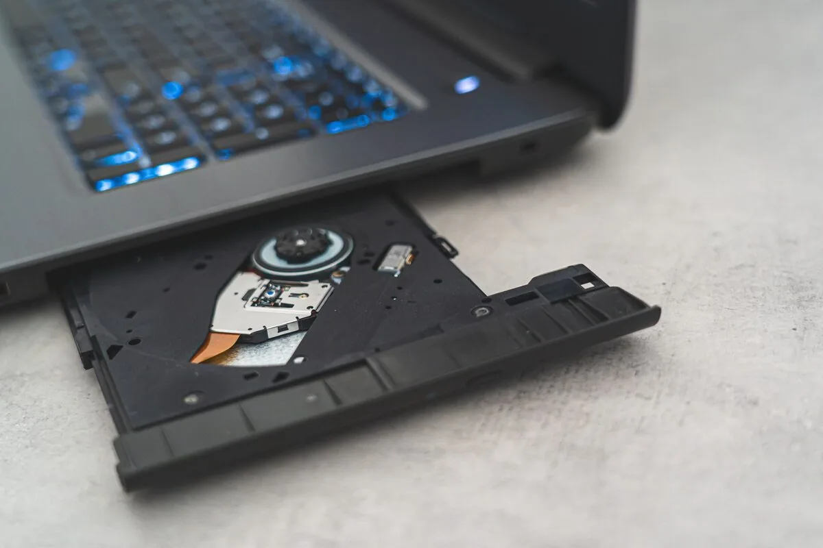 Wysunięta otwarta nagrywarka DVD w laptopie z podświetlaną klawiaturą — czytnik kart SD w laptopie Lenovo nie działa