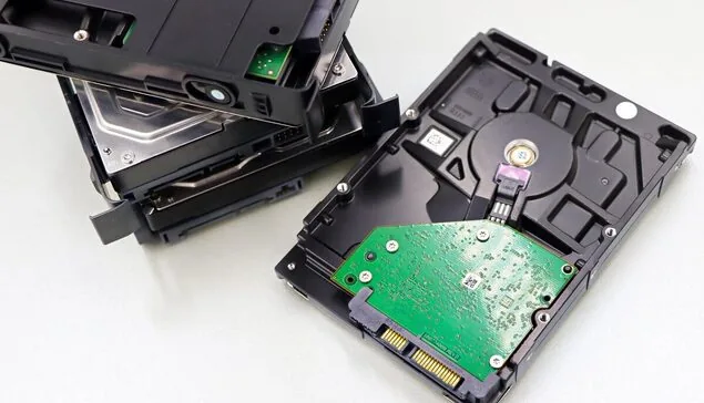 Dwa rozłożone dyski twarde HDD na blacie, brak dysku SSD w kadrze — dysk twardy laptopa Lenovo zapełnia się bardzo szybko