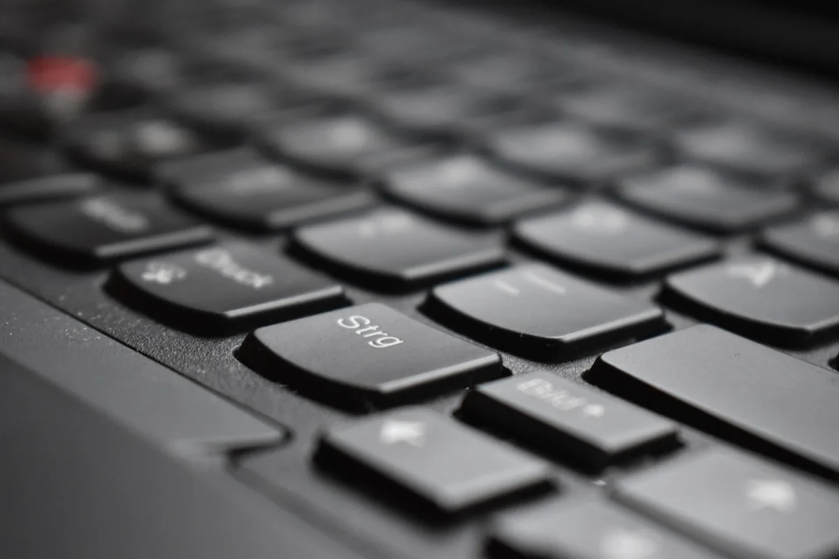 Zbliżenie na czarną klawiaturę laptopa biznesowego z czerwonym trackpointem — trackPoint w ThinkPadzie przestał działać poprawnie